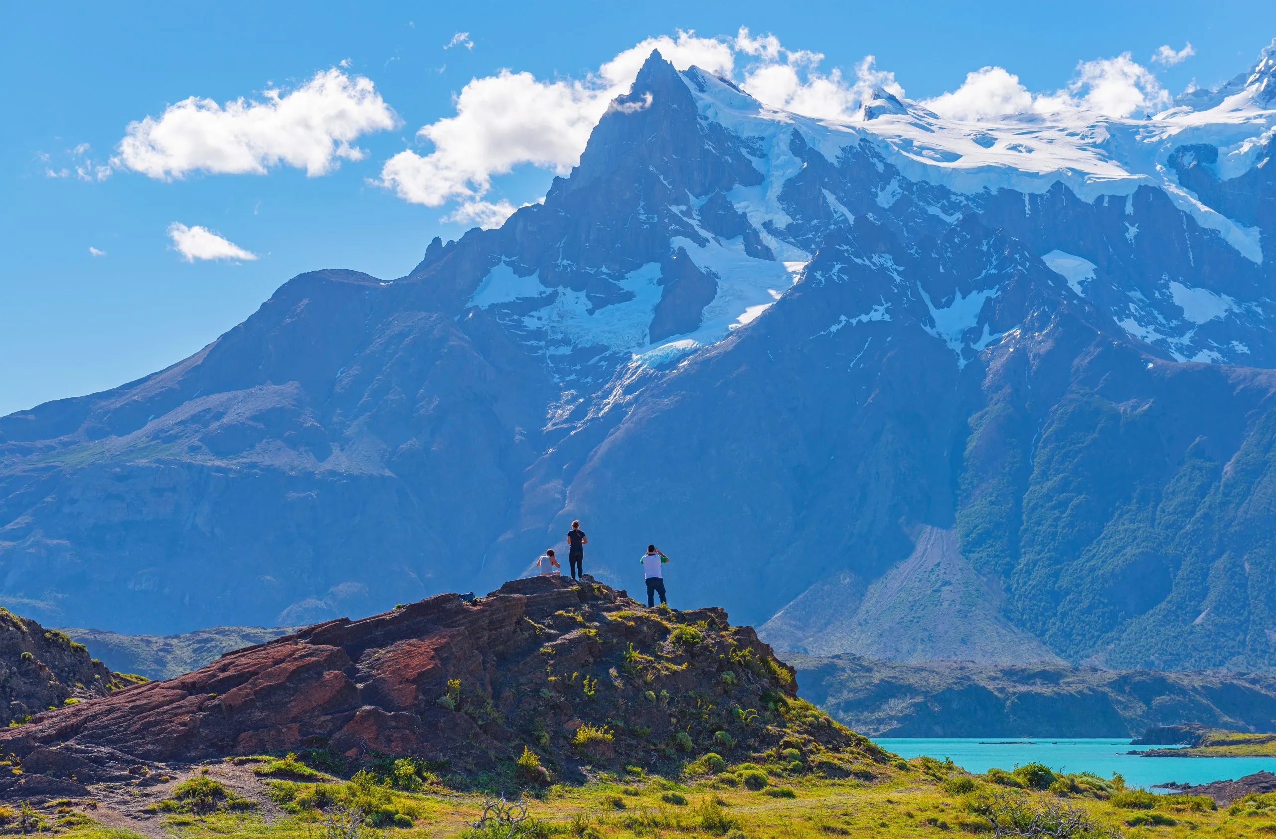 A couple of tourists / backpackers watching at the Cuernos del Paine peaks in the Torres del Paine national park in Patagonia, Chile.