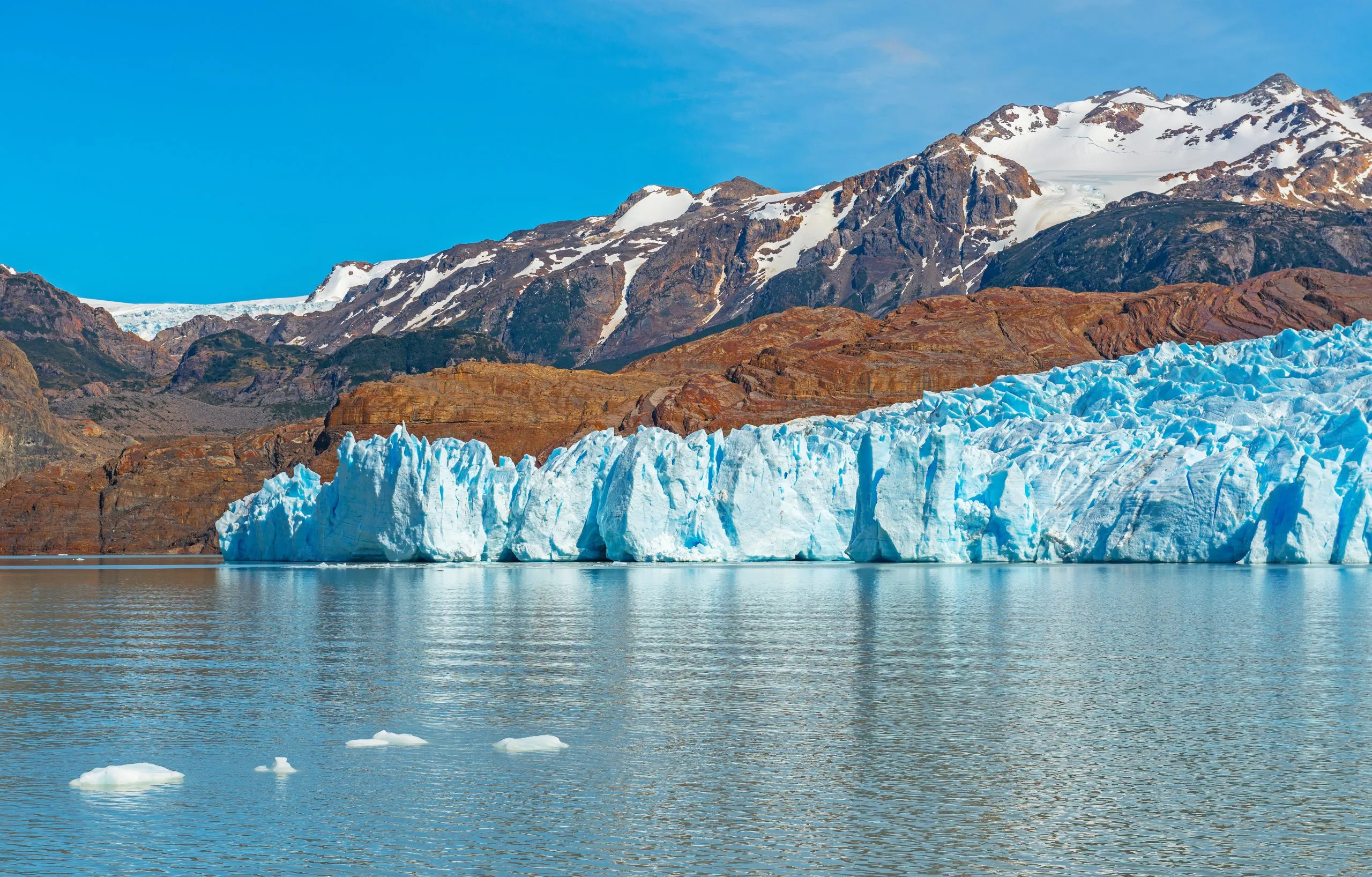 The majestic Grey Glacier in summer with small icebergs in Lago Grey with the Andes mountain range in the background, Torres del Paine national park, Puerto Natales, Patagonia, Chile.